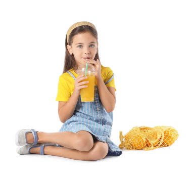 Beyaz arka planda portakal suyu içen tatlı küçük kız.