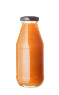 Beyaz arka planda lezzetli mango soslu bir şişe.