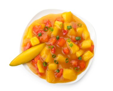 Beyaz arka planda lezzetli mango salatası ve soslu kase.