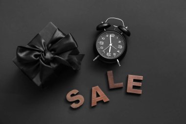 Koyu arkaplanda hediye kutusu, metin satışı ve alarm saati