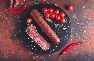 Lezzetli salamlı kompozisyon ve arkaplanda domatesler.