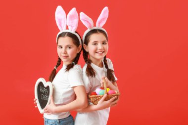 Renkli Paskalya yumurtaları olan şirin ikiz kızlar.