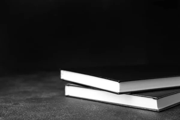 Stack of books on dark background, closeup