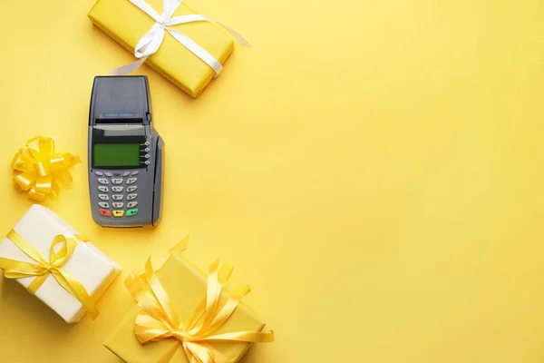 Payment terminal with gifts on color background