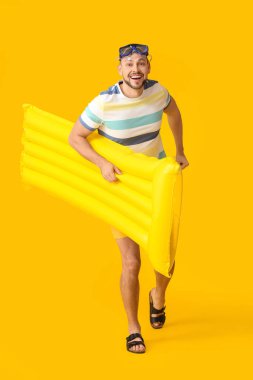 Arkaplanda şişme şiltesi olan yakışıklı bir adam.