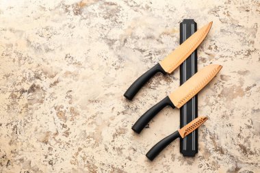 Grunge arka planında bıçak seti olan manyetik tutucu