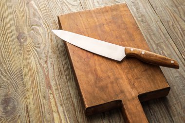 Ahşap zemin üzerinde bıçak olan tahta.