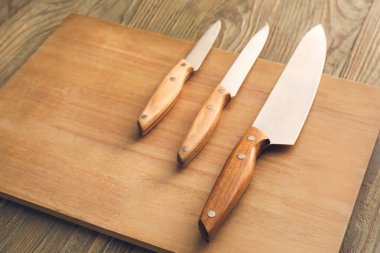 Ahşap zemin üzerinde bıçaklar olan tahta.