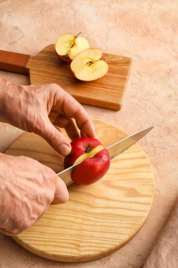 Arkaplanda olgun elma kesen adam