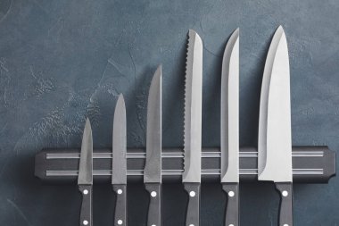 Renk arkaplanında bıçak seti olan manyetik tutucu