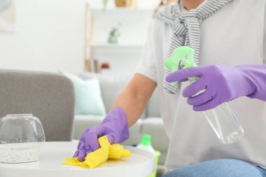 Genç adam dairesini temizliyor.