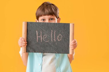 Renk arkaplanında yazı tahtası olan şirin bir çocuk.