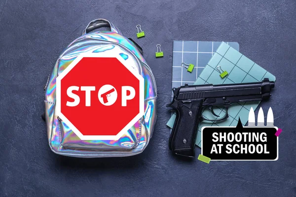 School backpack with gun and stationery on dark background. Problem of shooting at school