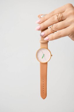 Hafif arka planda şık bir kol saati olan bir kadın.