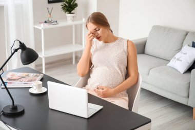 Evde çalışan stresli hamile kadın.