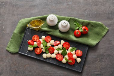 Mozarella peyniri, domates ve fesleğen ile koyu arkaplanda kompozisyon