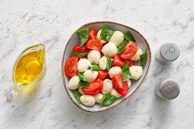 İçinde peynir, domates ve fesleğen olan bir kase.