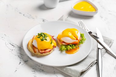 Hafif arka planda lezzetli yumurtalı Benedict tabağı.