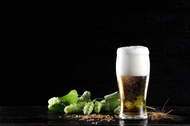 Koyu ahşap arka planda bir bardak taze bira