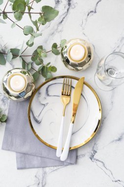 Yanan mumlar ve ışık arka planında çiçek dekoru olan güzel bir masa.