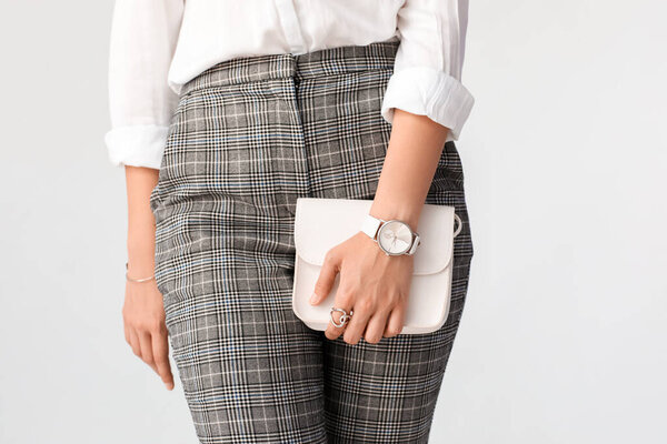 Женщина со стильными наручными часами на белом фоне