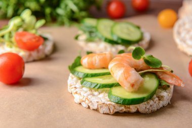 Salatalıklı pirinç krakeri ve parşömen üzerinde karides, yakın plan.