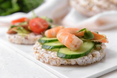 Açık arkaplanda pirinç krakeri olan tepsi