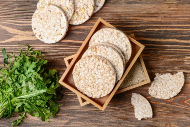 Tahta zemin üzerinde pirinç krakerleri olan bir kutu.