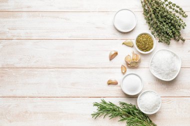 Hafif ahşap arka planda farklı baharat ve otlarla kompozisyon