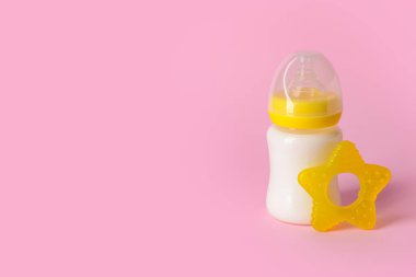 Bebek için bir şişe süt ve renk arka planında ip.