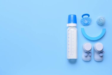 Bebek için bir şişe süt ve arka planda aksesuarlar