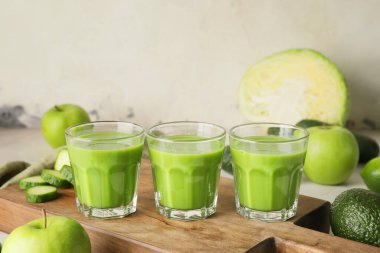 Sağlıklı yeşil meyve püresi ve malzemeler masada.