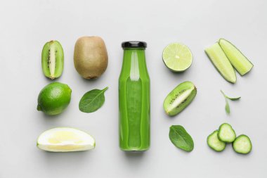 Sağlıklı yeşil smoothie şişesiyle kompozisyon ve hafif arka planda malzemeler