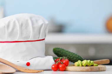 Mutfaktaki masada ürünleri olan şef üniforması.