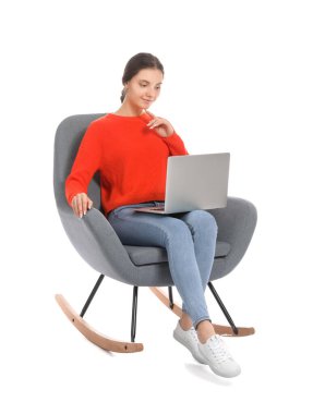 Dizüstü bilgisayarı beyaz arka planda koltukta oturan güzel genç bir kadın.