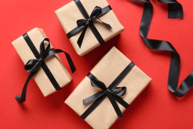 Arkaplanda hediye kutuları ve siyah kurdeleler