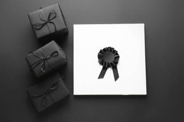Arkaplanda hediye kutuları, kurdele rozeti ve kart