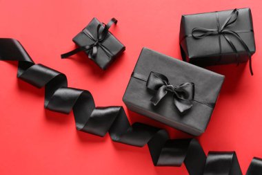 Arkaplanda siyah hediye kutuları ve kurdele