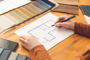 Ofisinde ev planı olan kadın iç mimar.