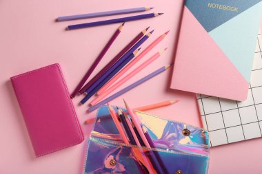 Renk arkaplanı üzerine kalemler, dosya ve defterler