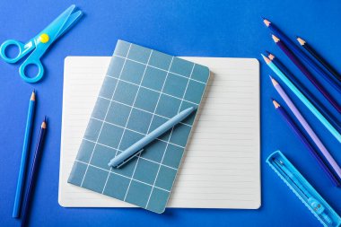 Renkli arka plan üzerinde renkli kalemler ve kırtasiye malzemesi olan kompozisyon