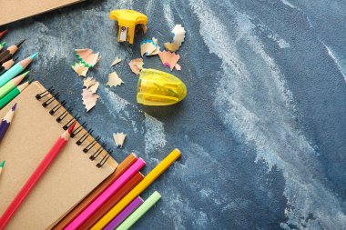 Renk arkaplanı üzerine kalemler, kalemler ve defterler