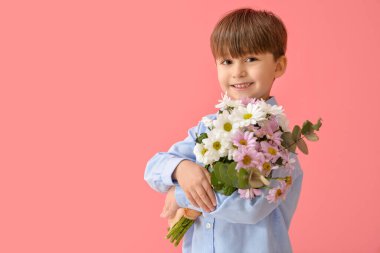 Renkli arka planda bir buket güzel çiçeği olan sevimli küçük bir çocuk.