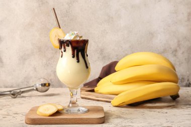 Arkaplanda bir bardak lezzetli muzlu milkshake.