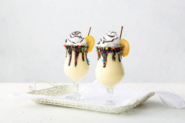 Hafif arkaplanda lezzetli muzlu milkshake bardakları