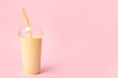 Renkli arkaplanda plastik muzlu milkshake.
