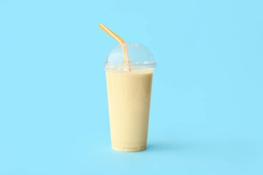 Renkli arkaplanda plastik muzlu milkshake.