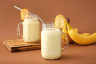 Renkli arkaplanda lezzetli muzlu milkshake kavanozları