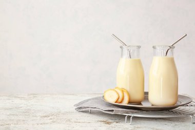 Hafif arkaplanda lezzetli muzlu milkshake şişeleri