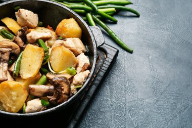 Lezzetli sebzeli tava ve arka planda tavuk, yakın plan.